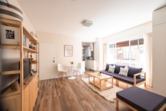 a living room with a blue couch and a wood floor