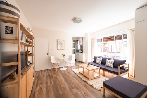 a living room with a blue couch and a wood floor