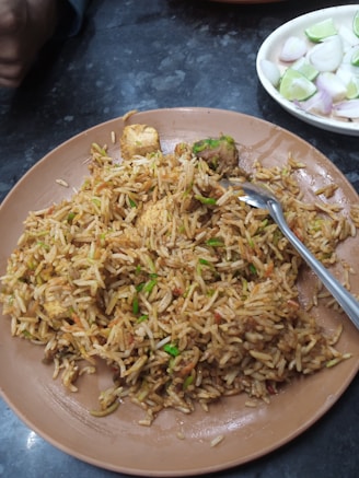 A bowl of fragrant Sri Lankan fried rice garnished with herbs and lime.