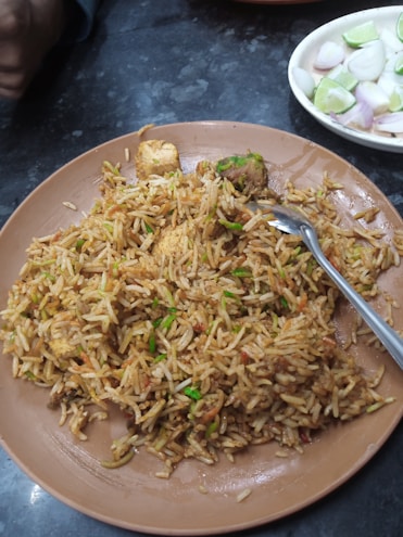 A bowl of fragrant Sri Lankan fried rice garnished with herbs and lime.