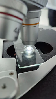 A clear, minimalist microscope lens focusing on a single cell, symbolizing precision in scientific research.