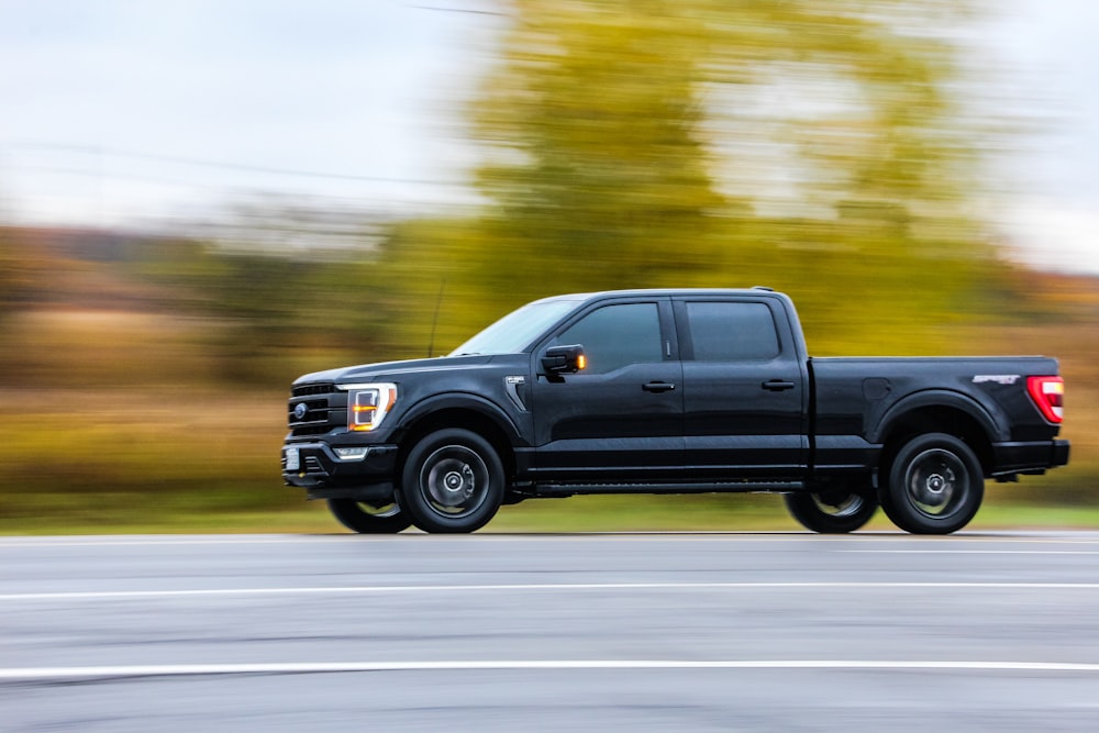 a black pickup truck on a road