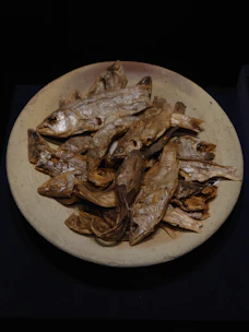 Assorted dehydrated treats including chicken feet, beef ears, and dried fish arranged on a wooden board.