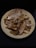 A plate filled with several dried fish, arranged in a somewhat haphazard manner. The fish have a distinctly brown and desiccated appearance, indicating they have been preserved.