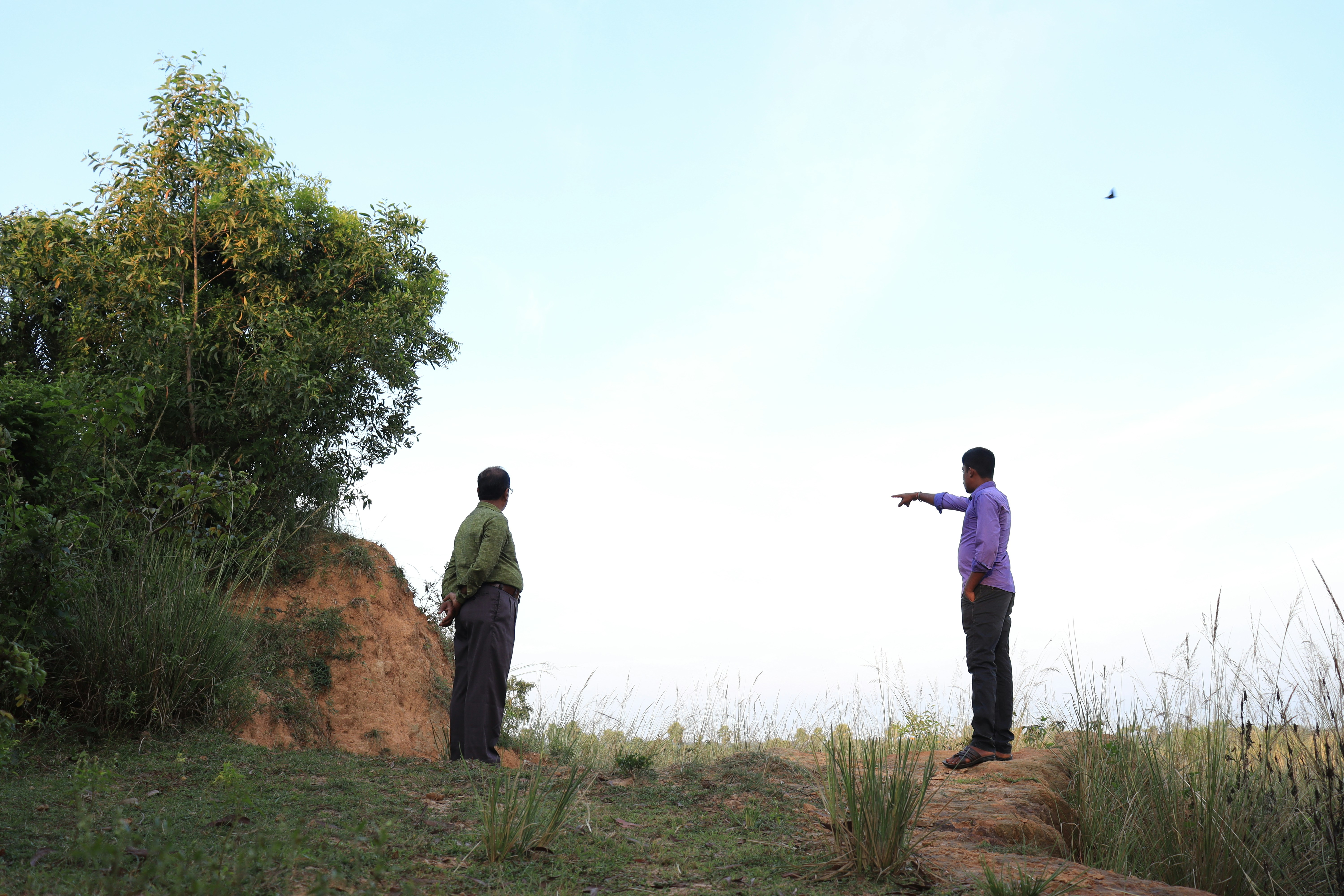 two men standing on a hill