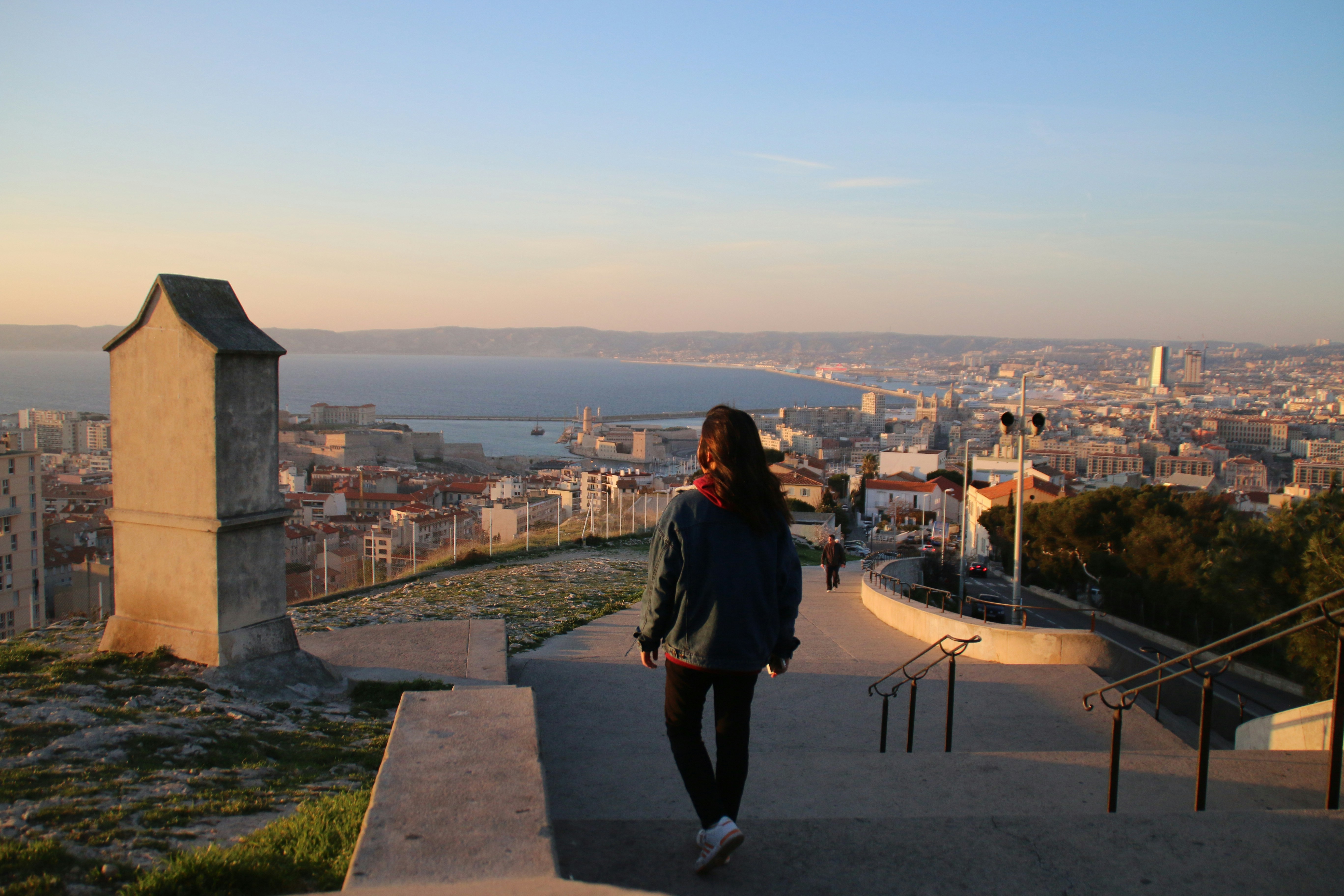 a person walking on a path overlooking a city