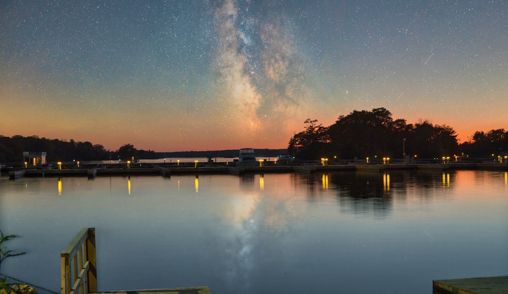 a body of water with trees and a bridge in the background