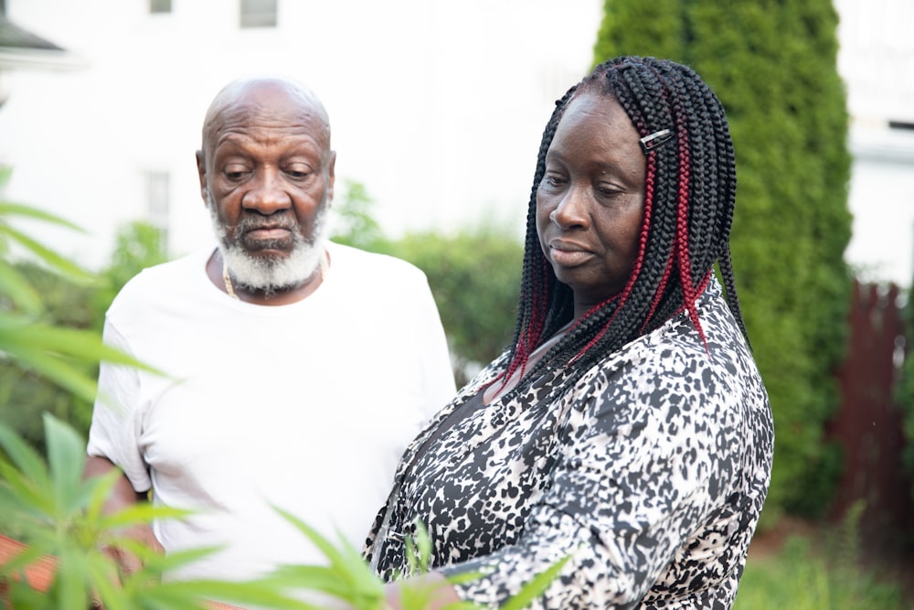 a man and woman standing next to each other outside