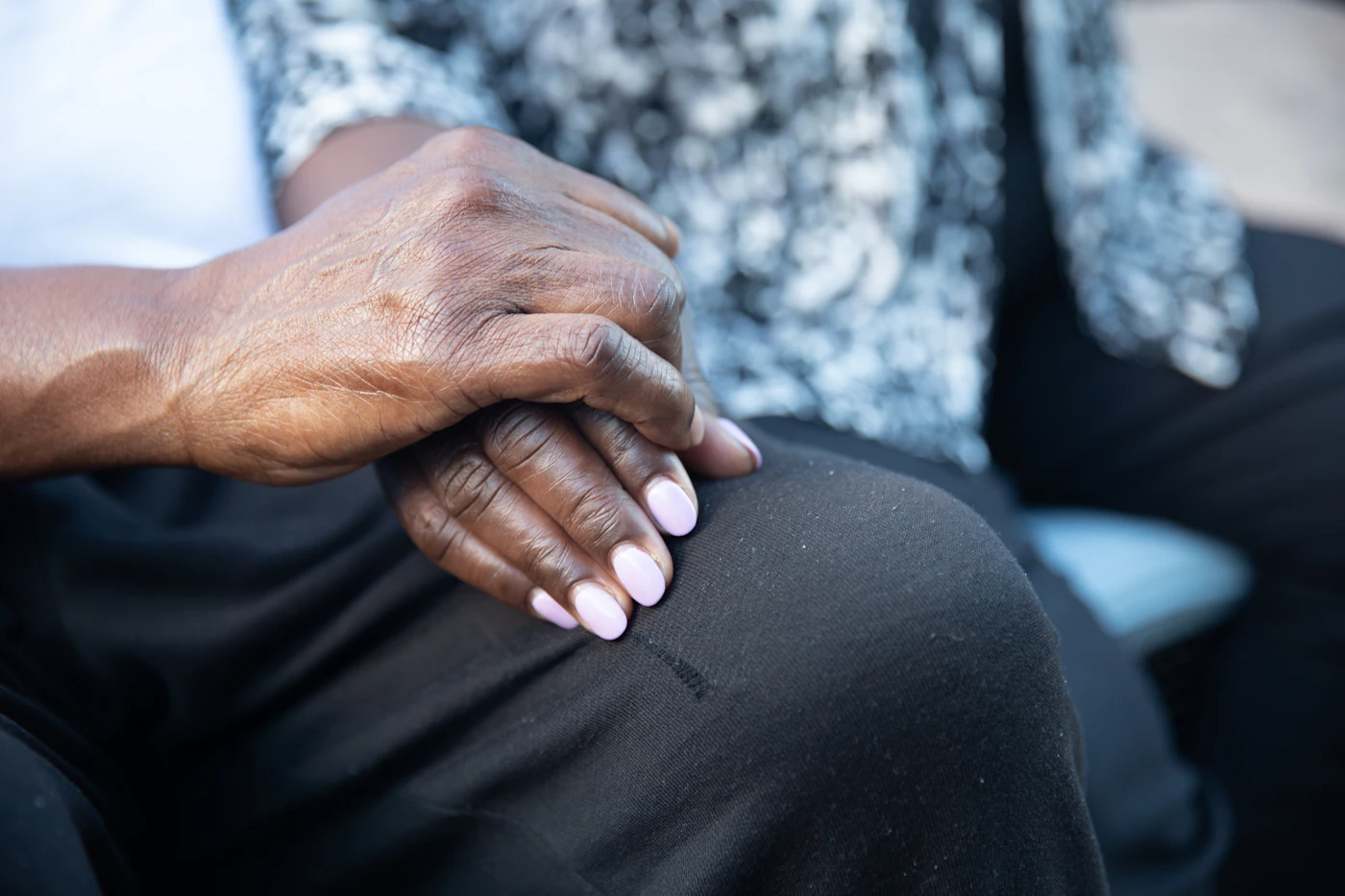 A person's hands resting calmly on their lap