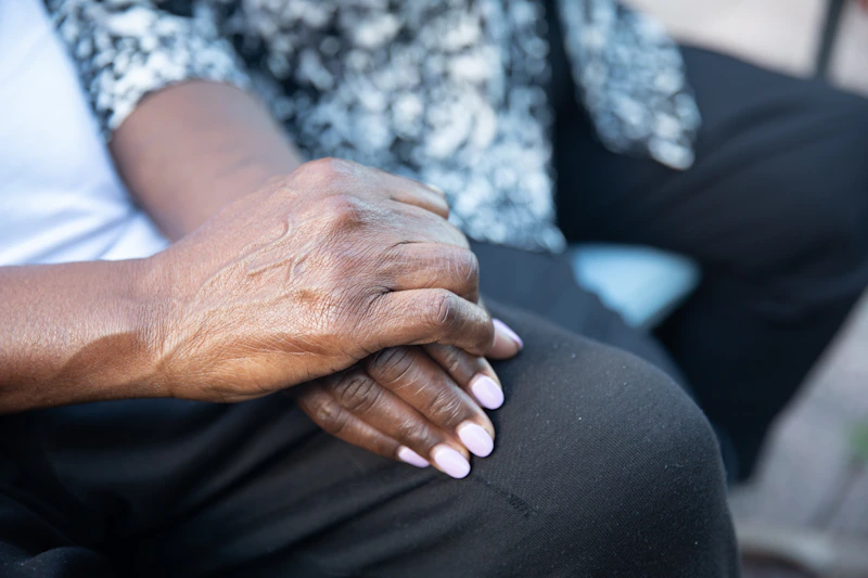 close-up of hands resting gently on lap