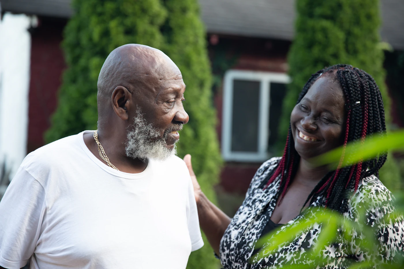 Older father smiling with his adult daughter outdoors