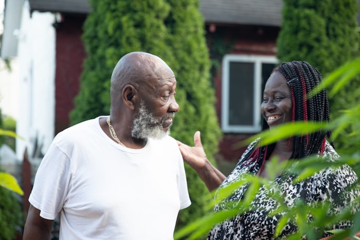 A Black elder couple laughing together in a garden