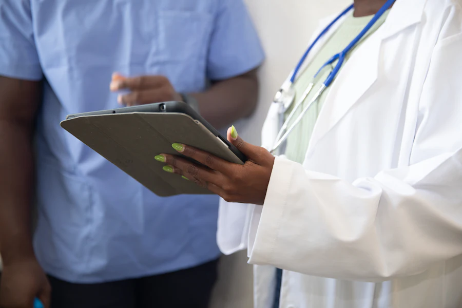 Médico mostrando información clínica en una tablet durante una consulta