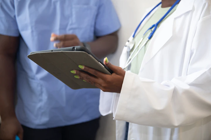 Doctor showing patient information on a tablet, illustrating the trust-building digital interaction in healthcare website design