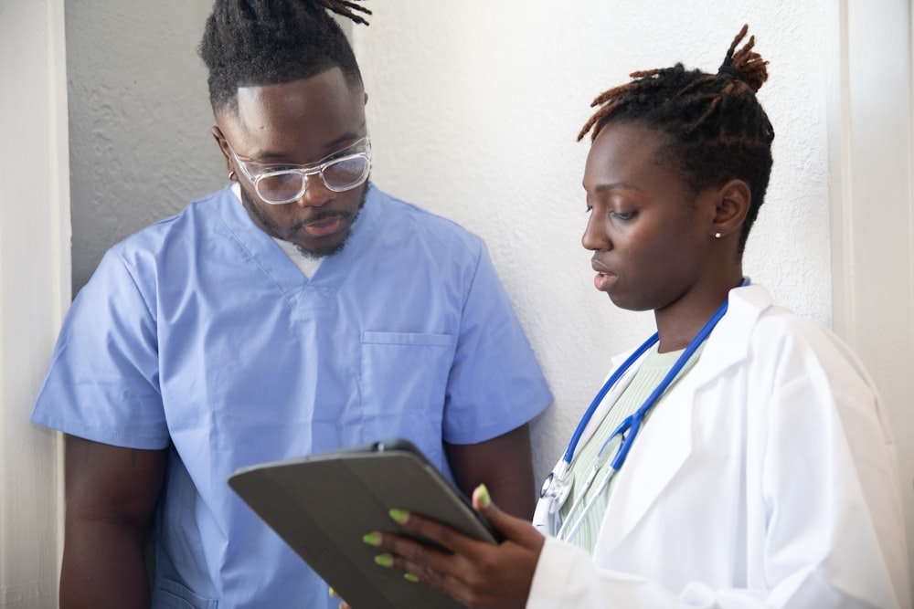 un médecin montrant quelque chose à un patient sur la tablette