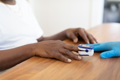 a person's hands on a table with a game controller
