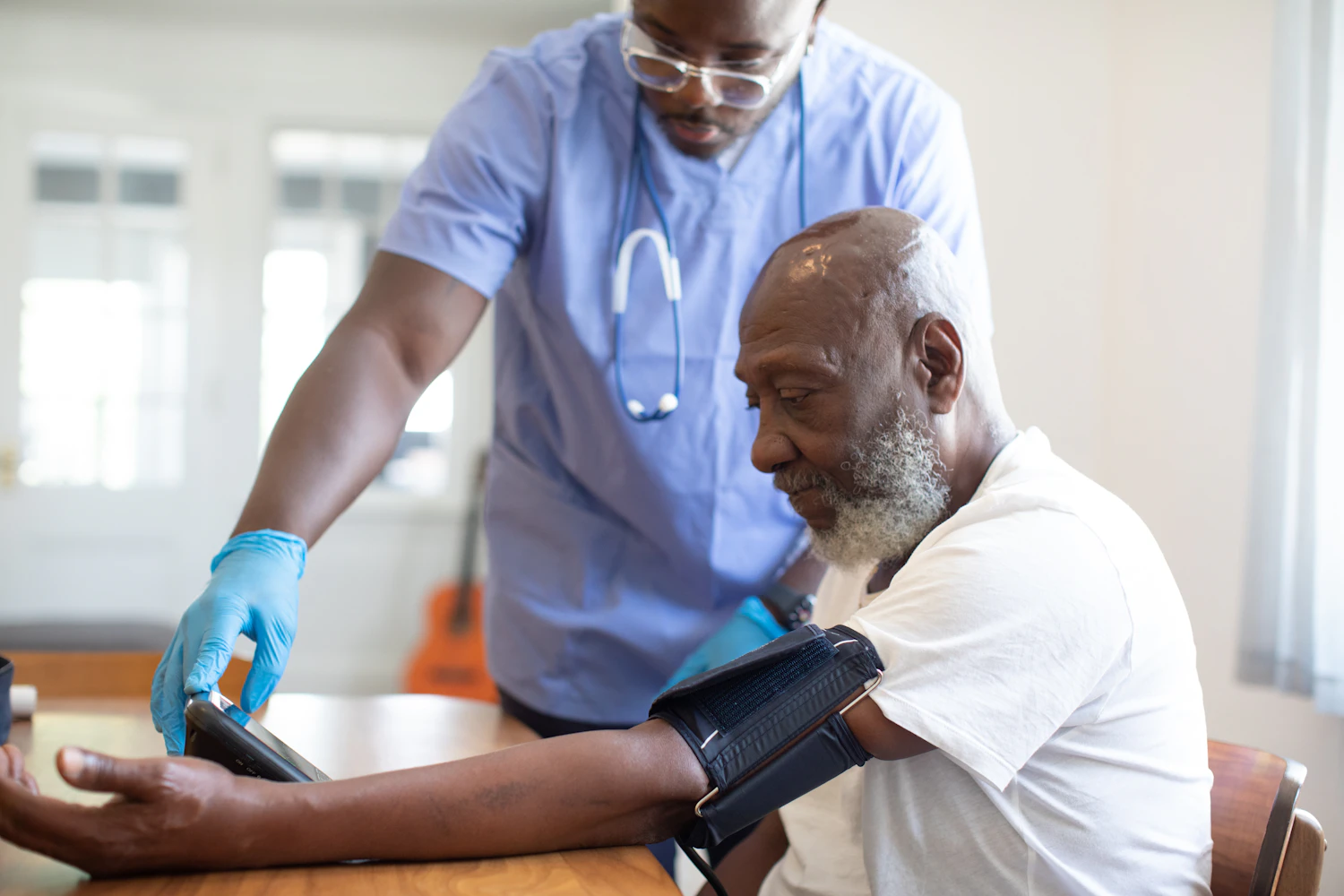Clinician checking an adult patient's blood pressure