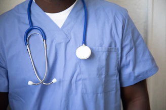 A person in blue medical scrubs with a stethoscope around their neck
