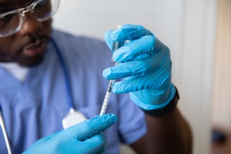a man in a blue lab coat holding a syringe