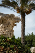 Close-up of elegant concrete decorative column in a garden setting.