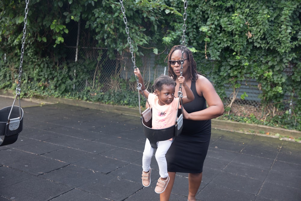 a woman and a child on a swing