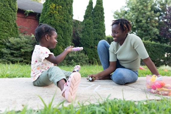 a person and a child sitting on a stone ledge