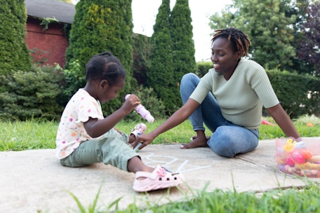 a person and a child playing with toys on a sidewalk