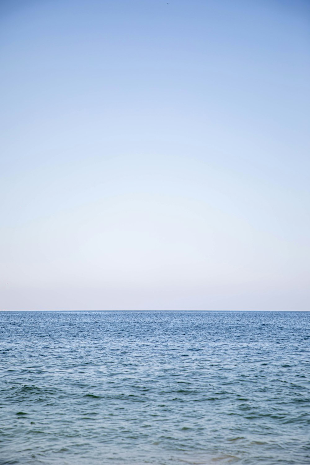 a body of water with a blue sky above it