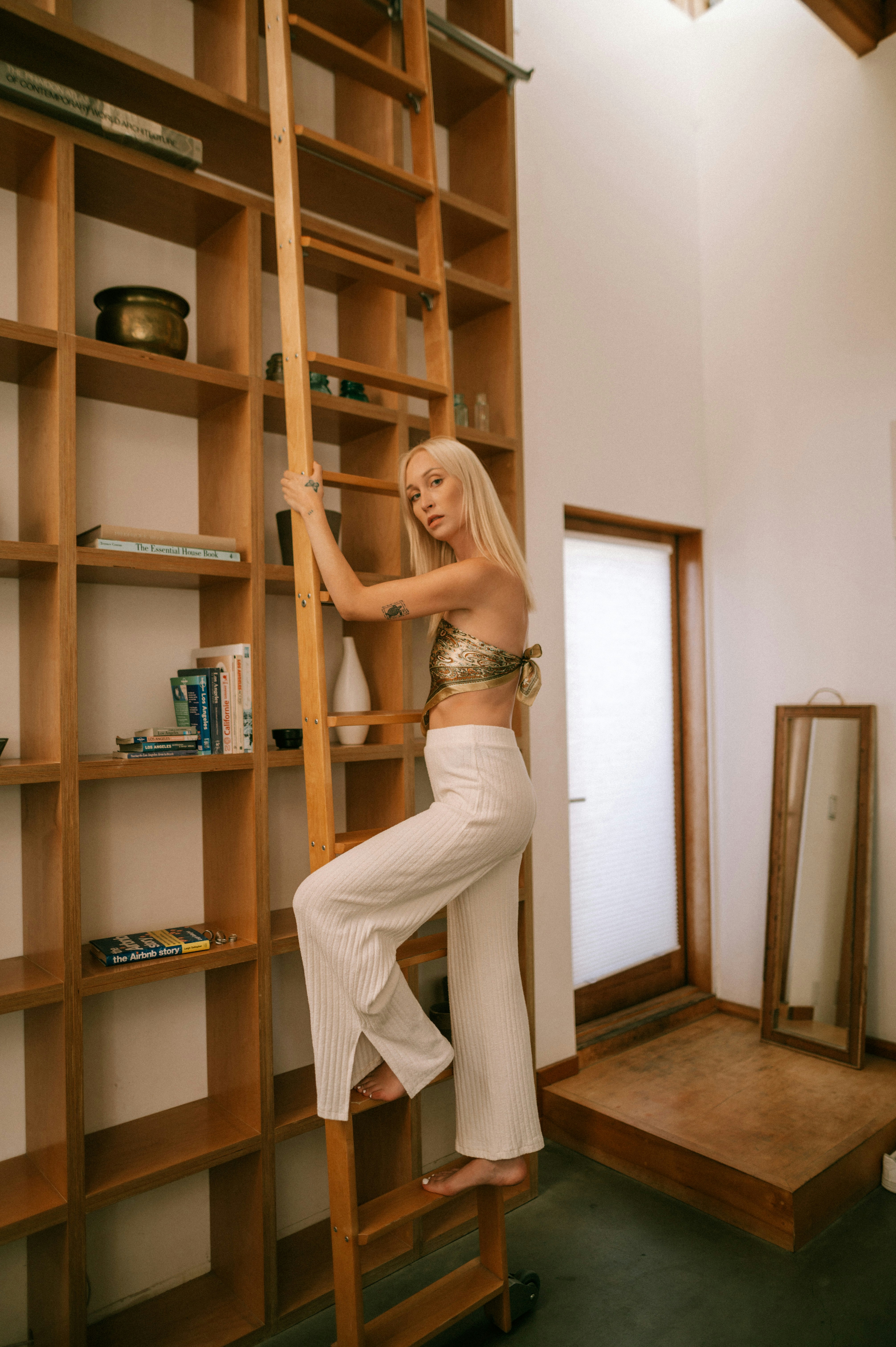 a man posing in front of a book shelf