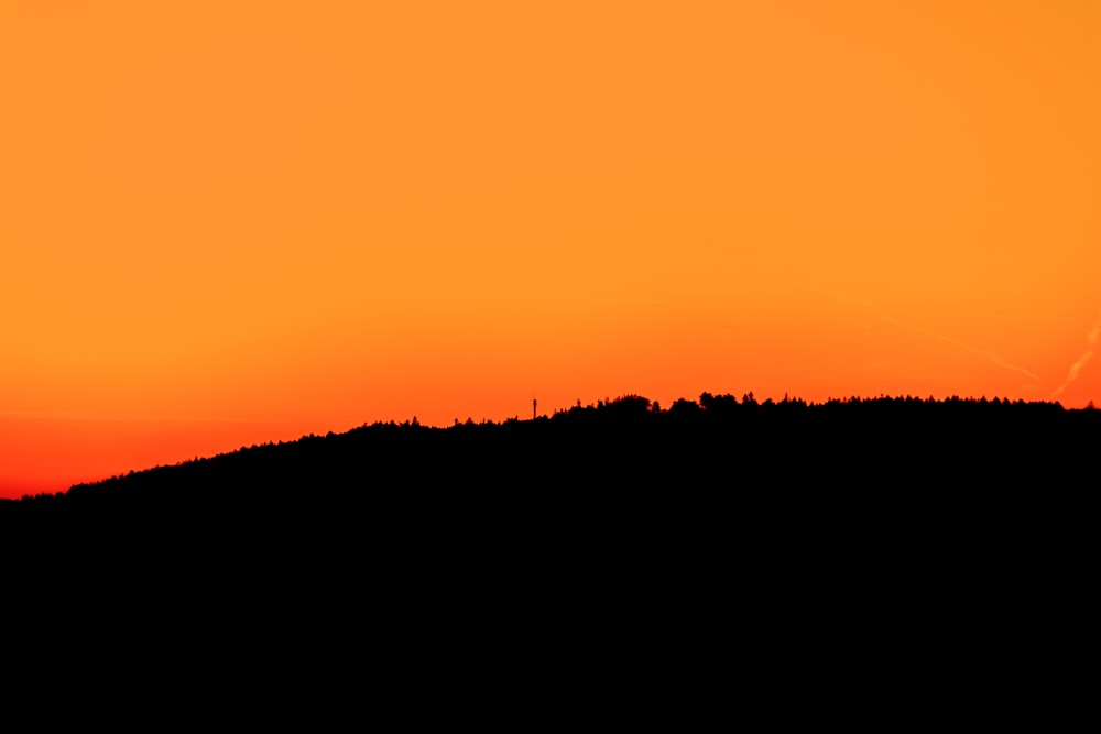 a sunset over a hill