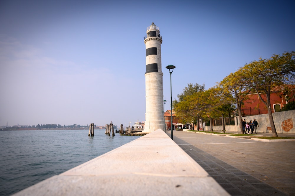 a white tower by a body of water