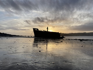 A calm sea at dawn with the silhouette of the rescue ship on the horizon.