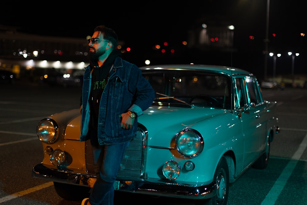 a person standing next to a blue car