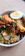 Close-up of a steaming clay pot biryani with vibrant spices and fresh herbs.