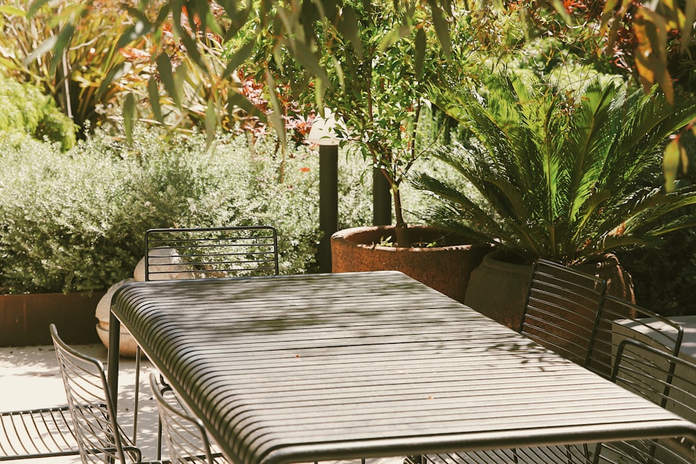 a table with chairs and plants in the back