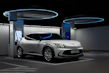 Shiny silver electric car charging at a modern station