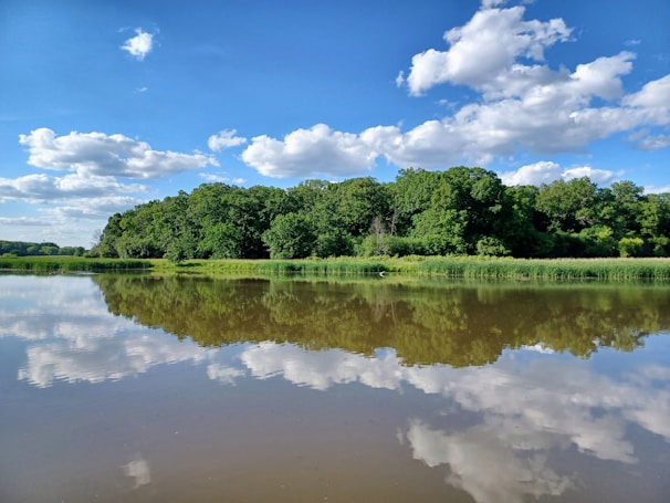 A calm lake reflecting the sky, symbolizing tranquility achieved through breathing techniques.