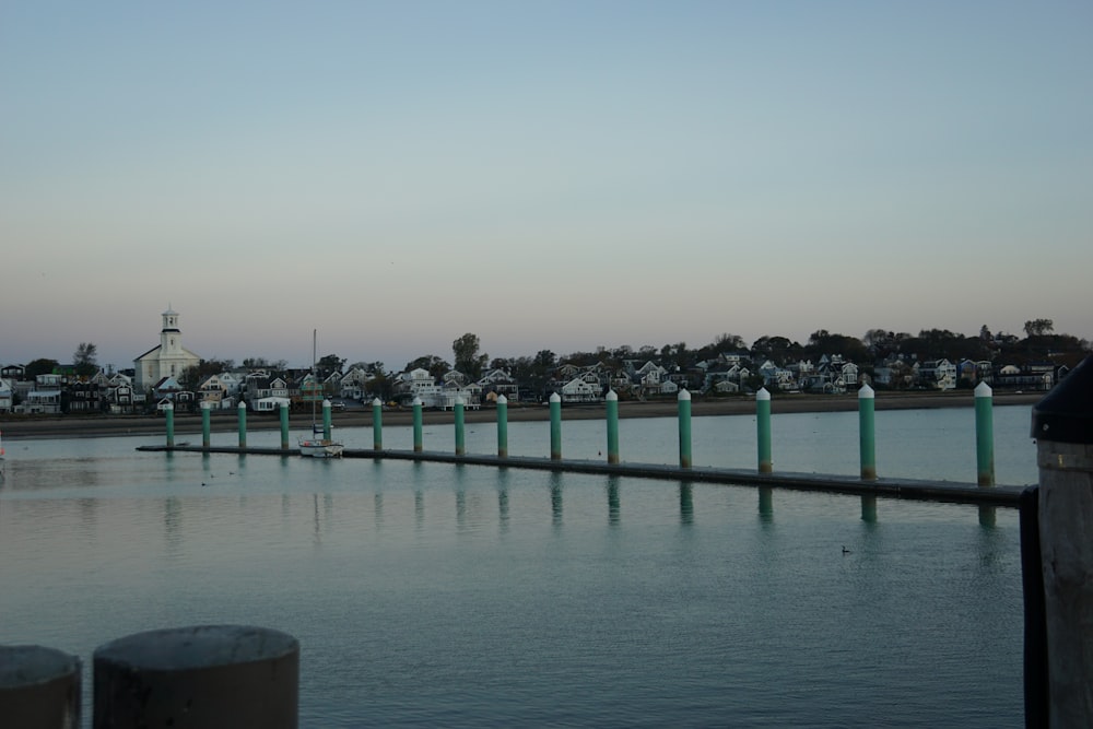 a dock with boats in a body of water with buildings in the background