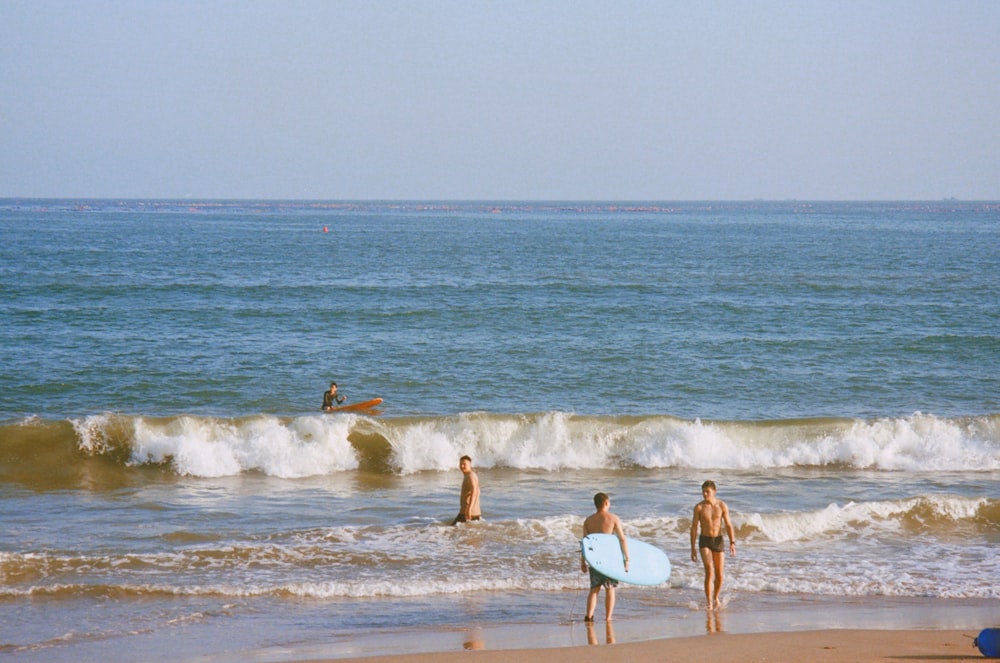 personnes avec des planches de surf sur la plage