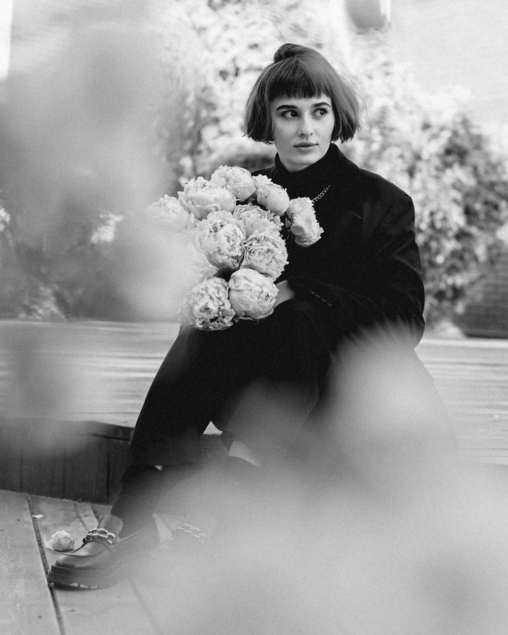 a person sitting on the ground holding flowers