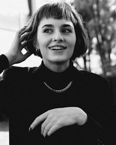 a person smiling with the hands on the head