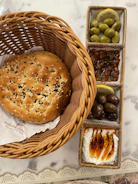 Artisan bread basket paired with plentyfoods tahini and fresh herbs.