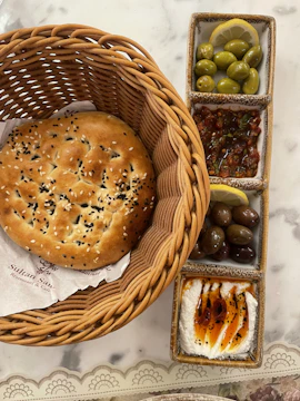 Artisan bread basket paired with plentyfoods tahini and fresh herbs.