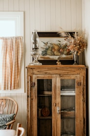 a cabinet with a vase and glass on top