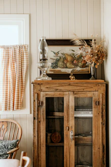 a cabinet with a vase and glass on top