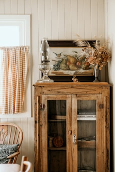 a cabinet with a vase and glass on top