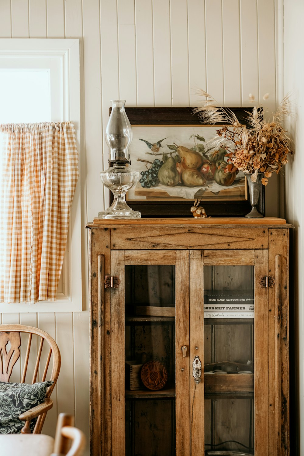 a cabinet with a vase and glass on top