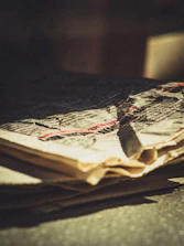 Close-up of vintage newspaper texture with visible aged creases and faded print.