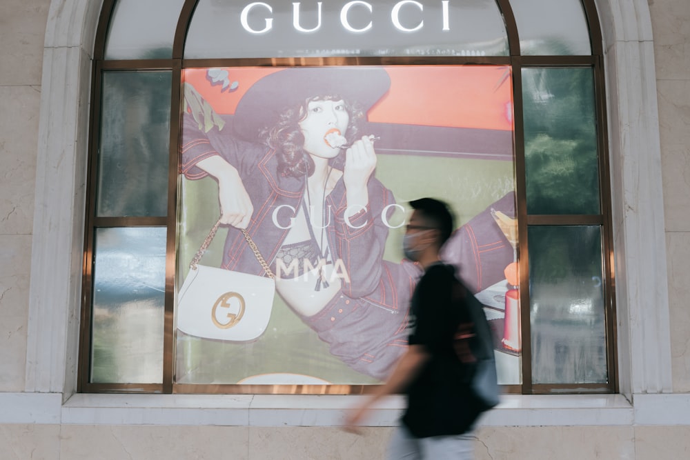 a man walking by a large poster