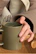 Close-up of a ceramic mug with a cool urban design, held by a person in a cozy setting.